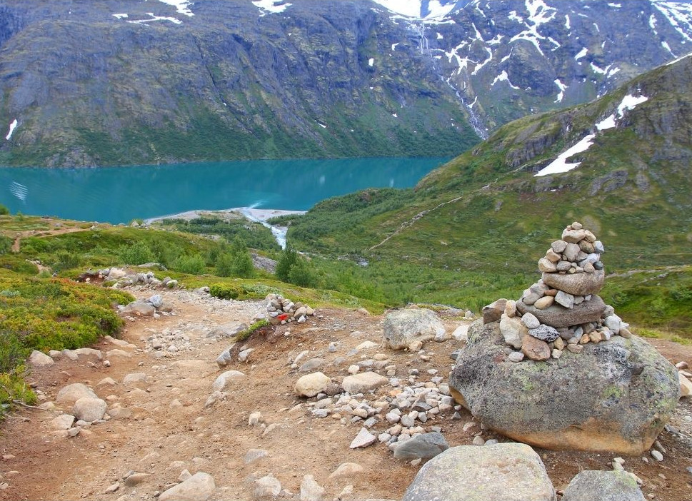 vandringsled i jotunheimen med smaragdgrön sjö i dalen