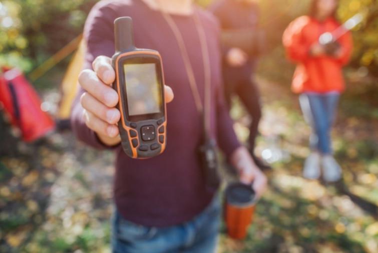 Håller upp satellittelefon i fjällen